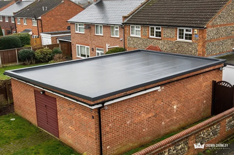 Brick garage with a new flat roof and metal edge trim