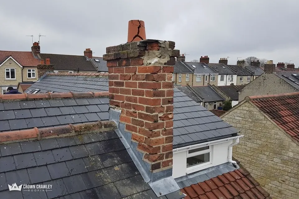 Brick chimney stack on a slate roof with lead flashing
