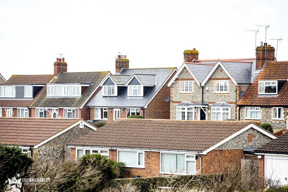 Houses with dormer windows and tiled roofs seen across back gardens