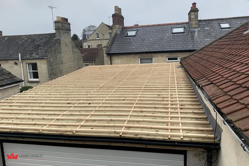 Timber battens laid over a garage roof beside a tiled slope