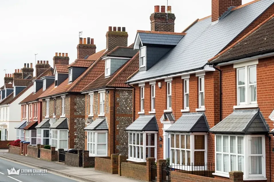 Red brick terrace with bay windows and slate roofs along a street
