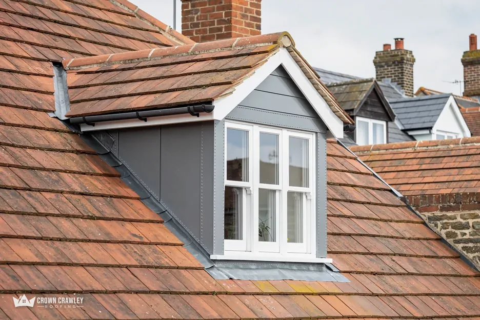 Lead-clad dormer window set into a red clay tiled roof