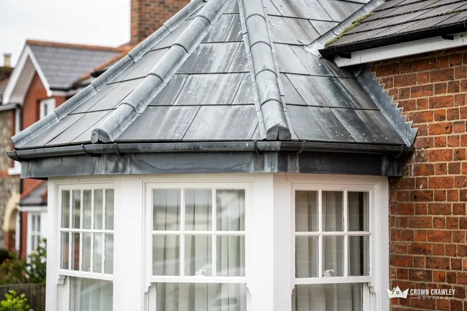 Lead-covered bay window roof on a brick house