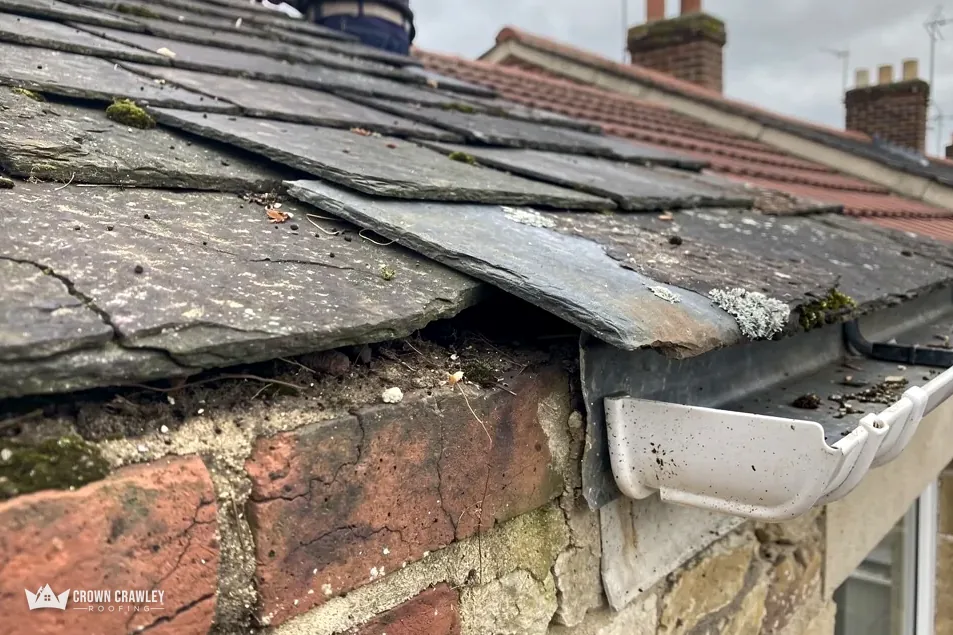 Slate edge, lead and guttering above a stone and brick wall