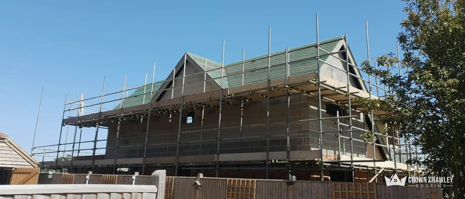 Scaffolded house with a new roof under construction
