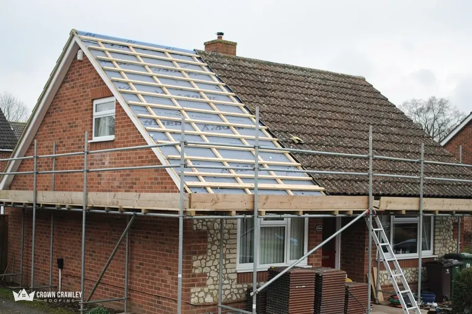 Brick bungalow with scaffold and new roof membrane on the slope
