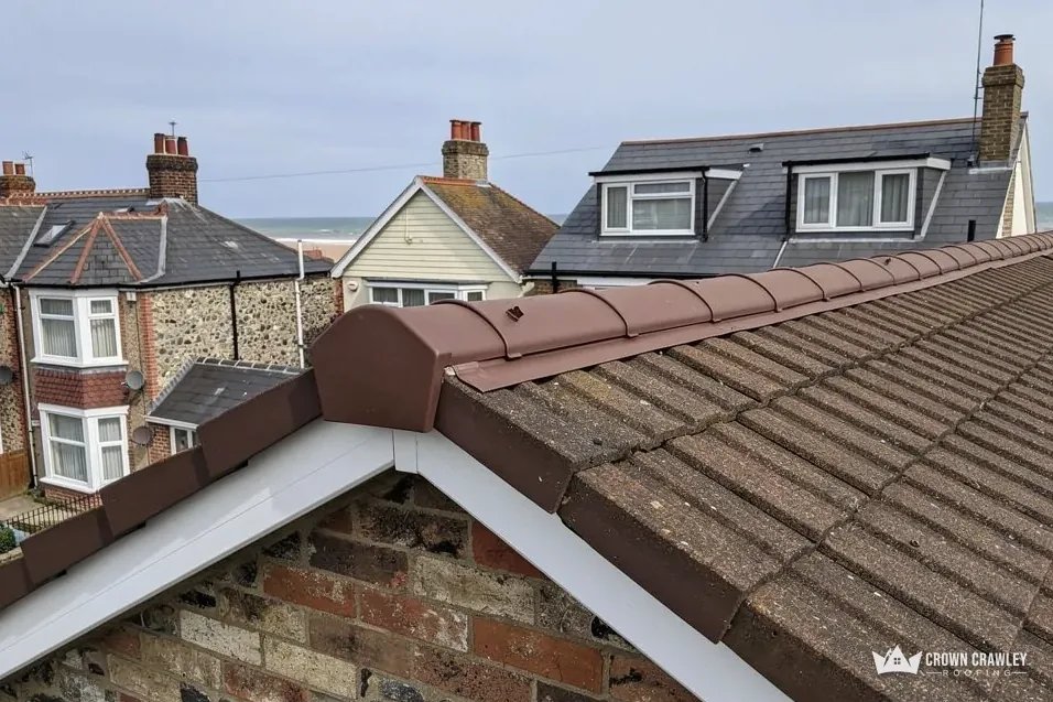 Tiled hip with a ridge cap above a brick gable