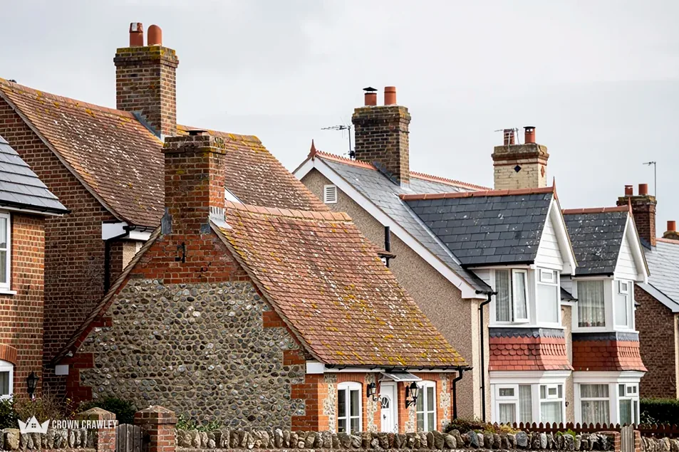 Flint and brick houses with clay tiled roofs and chimneys