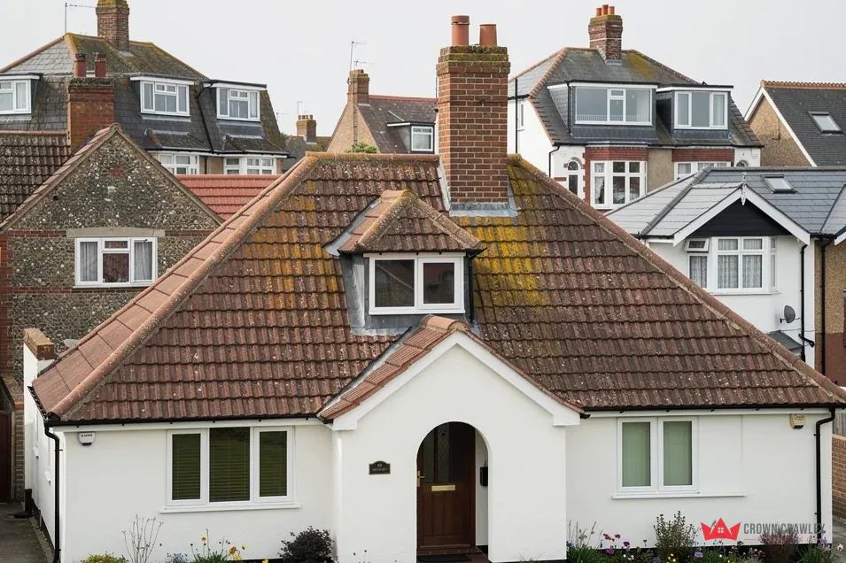White rendered bungalow with a hipped tiled roof and dormer