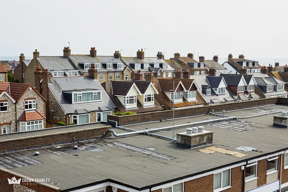 Flat roof in the foreground of a street of dormer-roofed houses