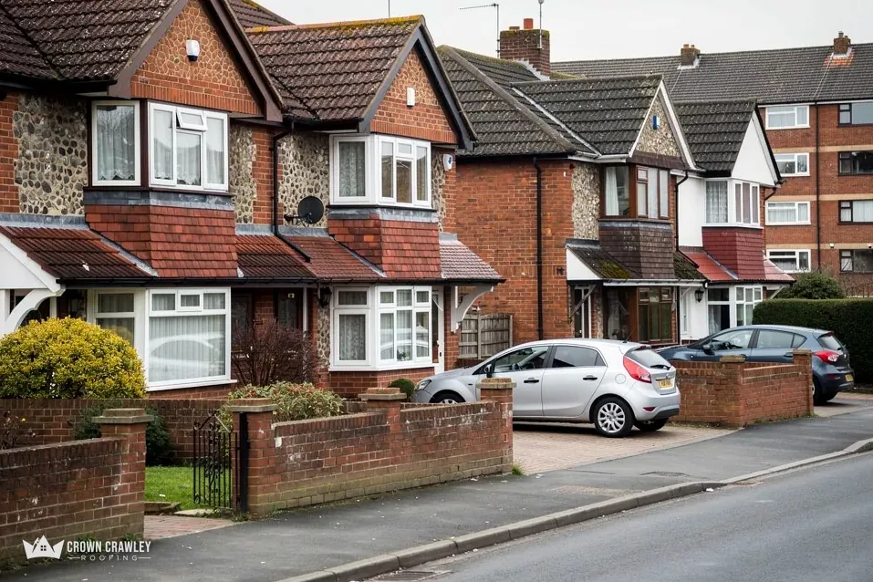 Brick semi-detached houses with tiled roofs and parked cars