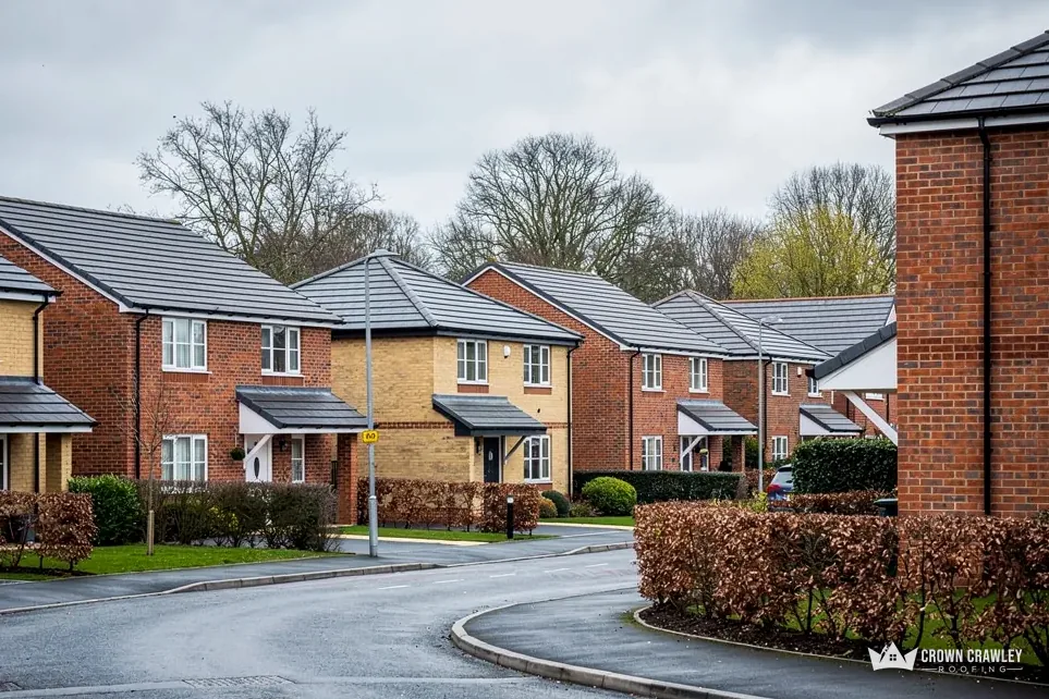 Modern estate road with brick houses and grey roof tiles