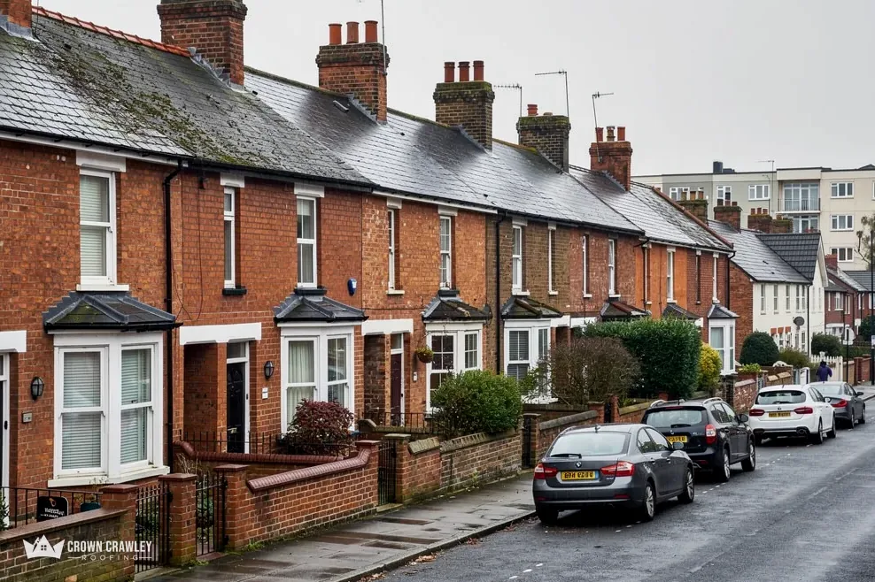 Victorian brick terrace with bay windows and parked cars