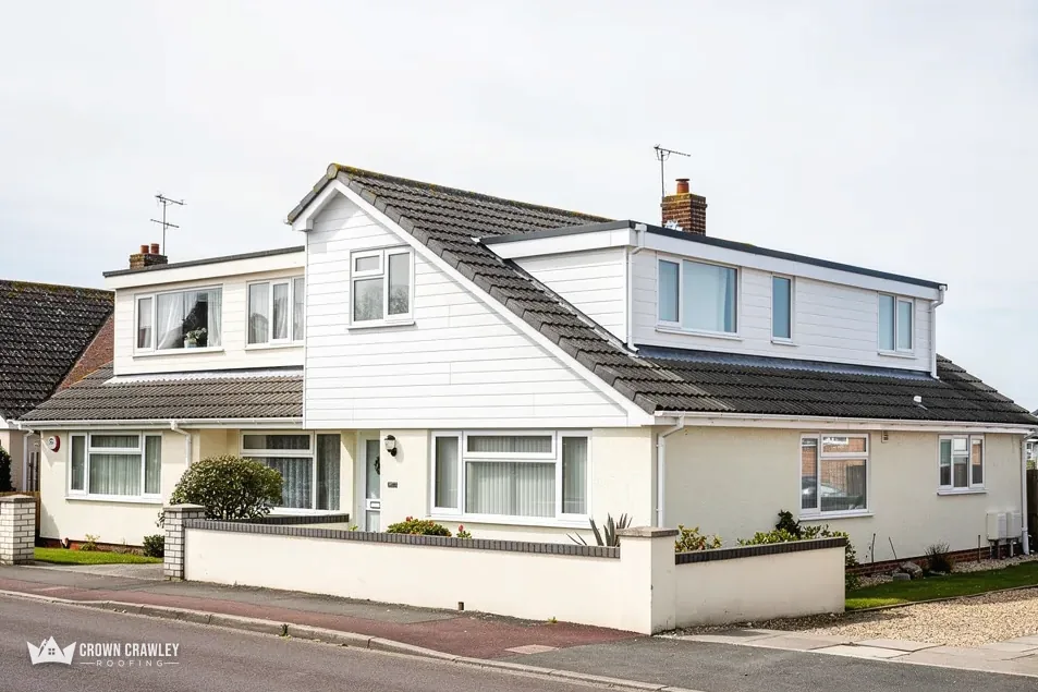 White dormer bungalow with a grey tiled roof on a quiet street