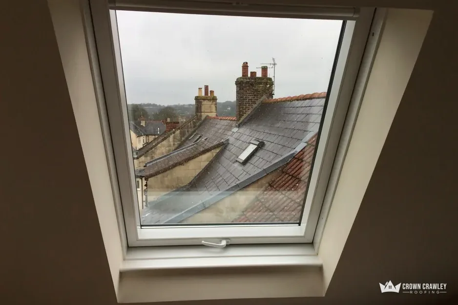 View through an open roof window over neighbouring tiled roofs